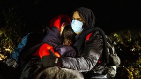 En mamma från Irak kramar sina döttrar, någonstans vid gränsen mellan Polen och Belarus