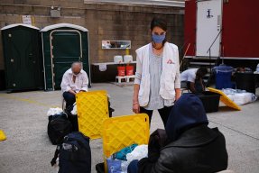 Renée Corbett, som arbetar med vatten och sanitet för Läkare Utan Gränser, pratar med en person som besöker våra tillfälliga duschar i samband med coronapandemin i New York, USA.