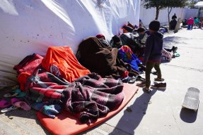 Flyktingar under filtar i ett läger