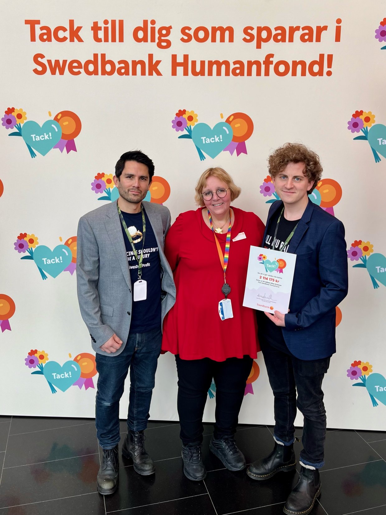 Två medarbetare från Läkare Utan Gränster står uppställda tillsammans med en representant från Swedbank Humanfond, de håller tillsammans ett diplom i handen
