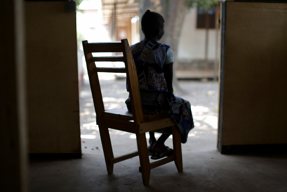 En kvinna i Centralafrikanska republiken sitter i en gungstol med ryggen mot kameran.