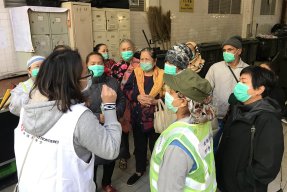 En hälsoinformatör från Läkare Utan Gränser talar med en grupp människor i Hong Kong om hur de kan skydda sig mot det nya coronaviruset. Februari 2020.
