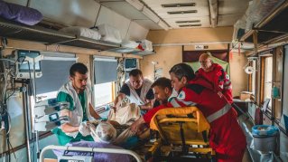 Sjukvårdspersonal tar hand om patient på sjukhuståget i Ukraina