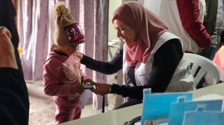 Ett barn i toppluva träffar en från Läkare Utan Gränser